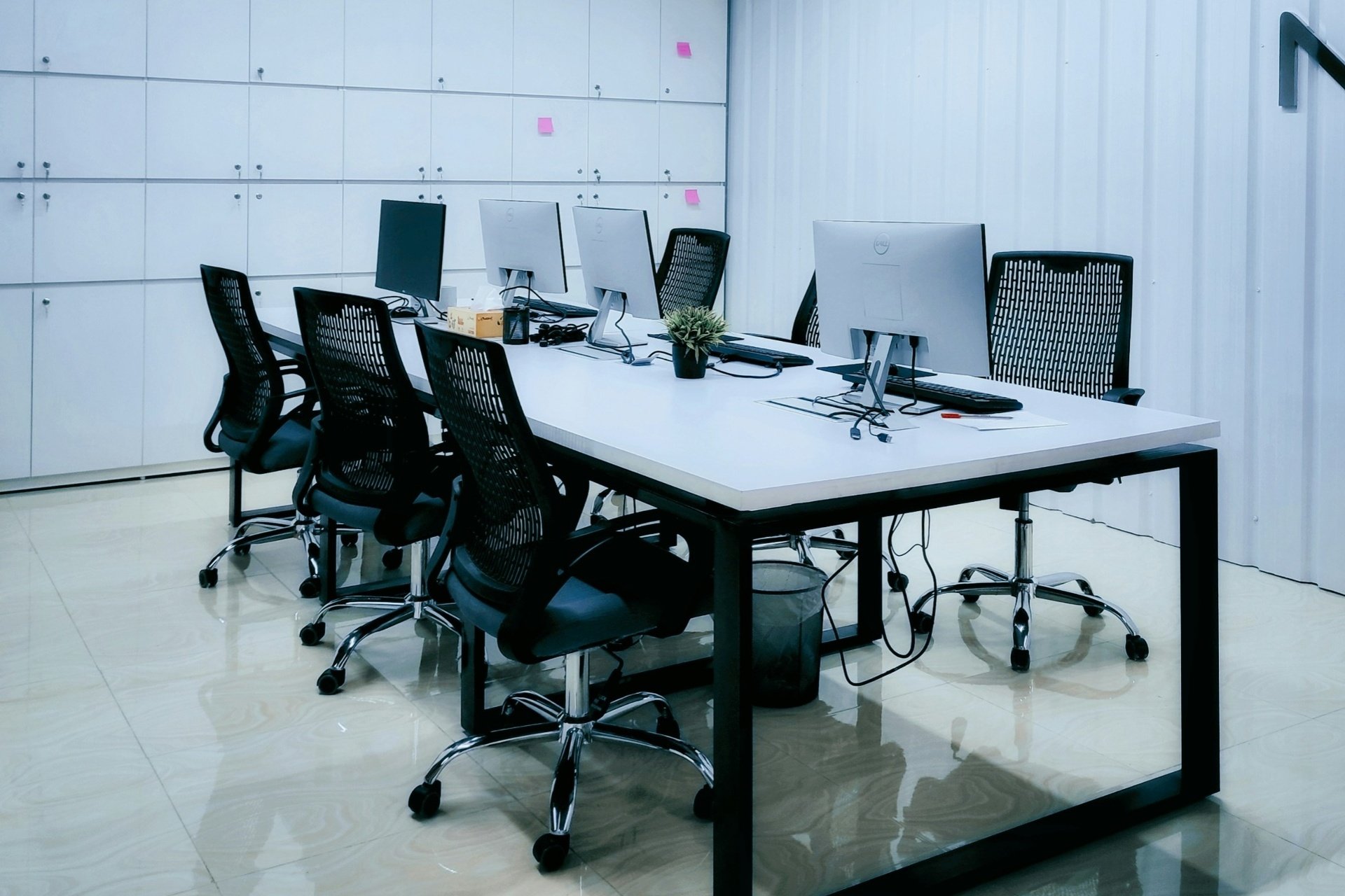 Moderní kancelář s pracovními stanicemi a ergonomickými židlemi pro týmy zabývající se ISO certifikací a ESG poradenstvím.